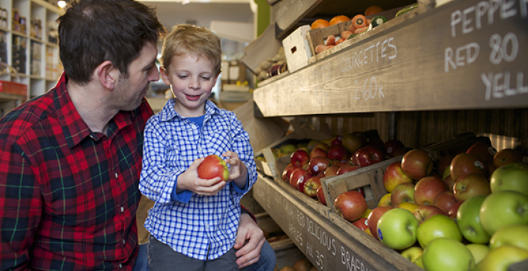 Boy picking out an apple in the supermarket