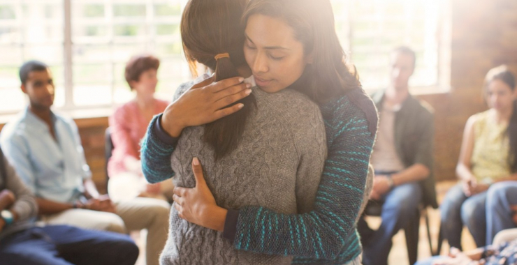 Women hugging in prayer circle